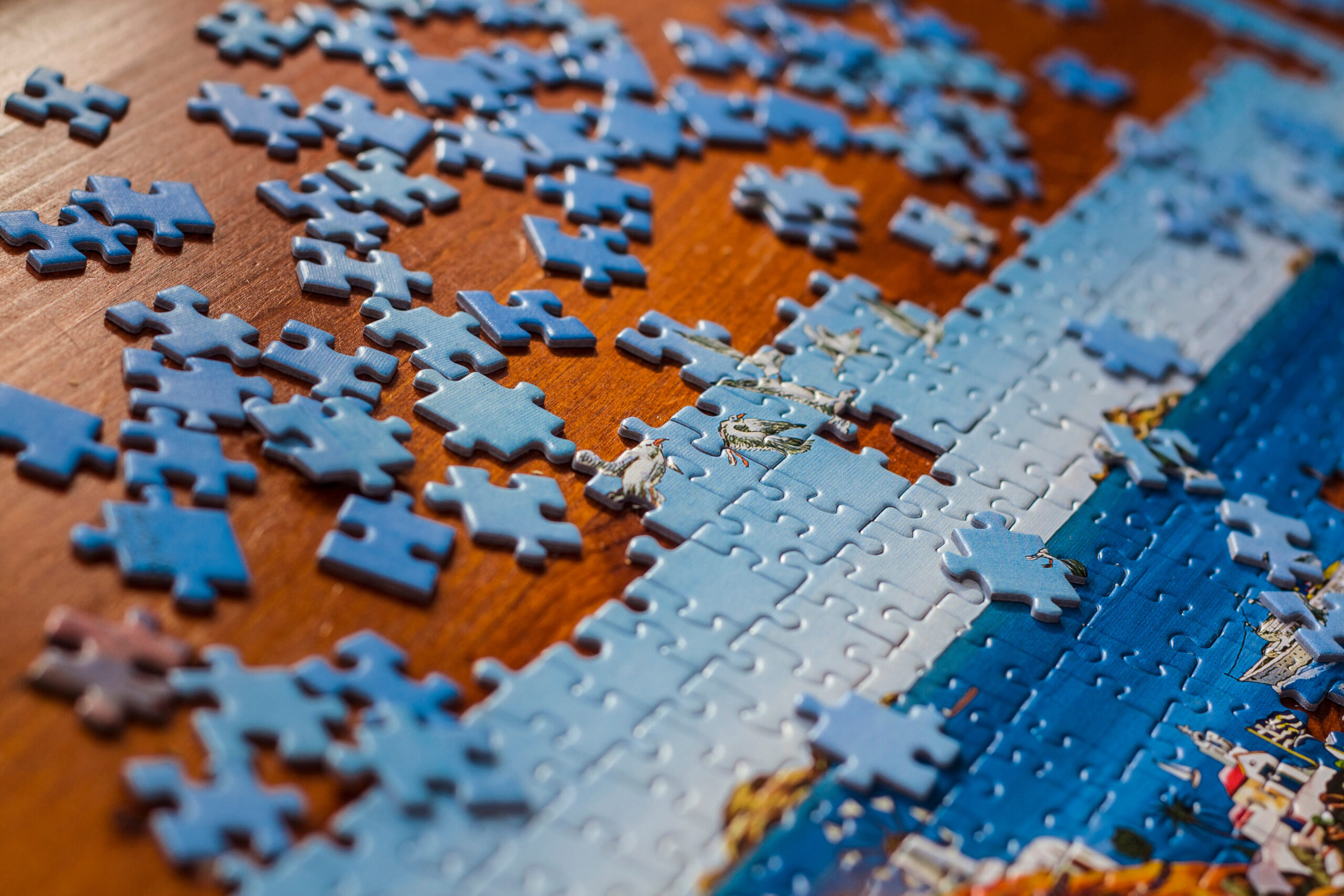 Partially solved jigsaw puzzle with scattered puzzle pieces on the table