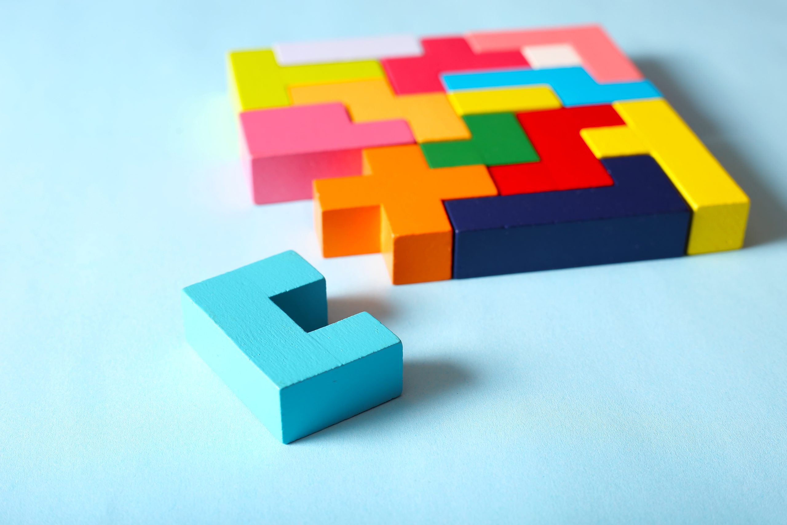 Simple solutions to solve problems. Strategy in business. Wooden Tetris cubes on a blue background as a puzzle symbol. The challenge with a difficult solution