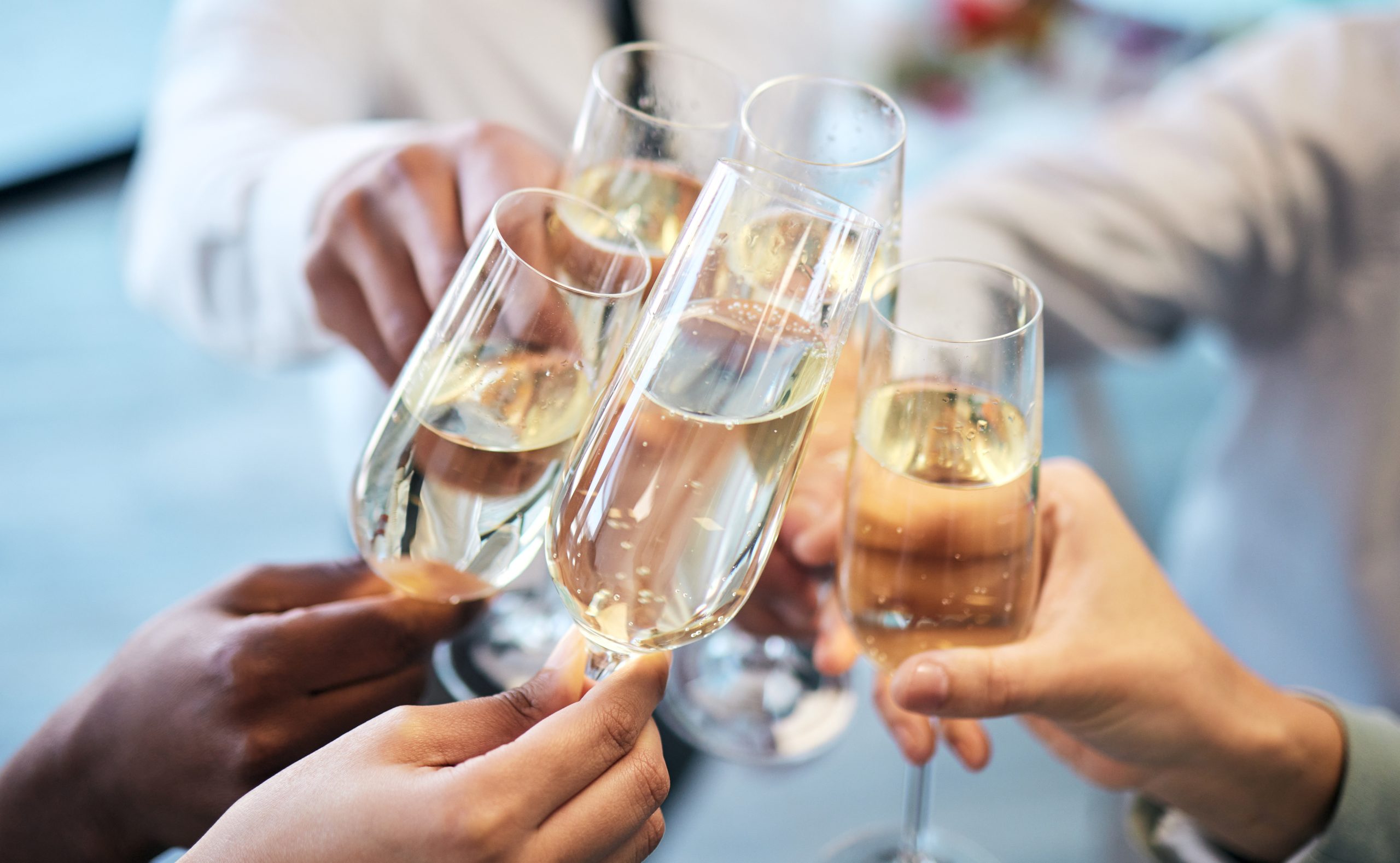 Champagne, toast and business people at an office party in celebration of success together closeup. Hands, glass and cheers with a team or group of colleagues in the workplace to celebrate a goal.