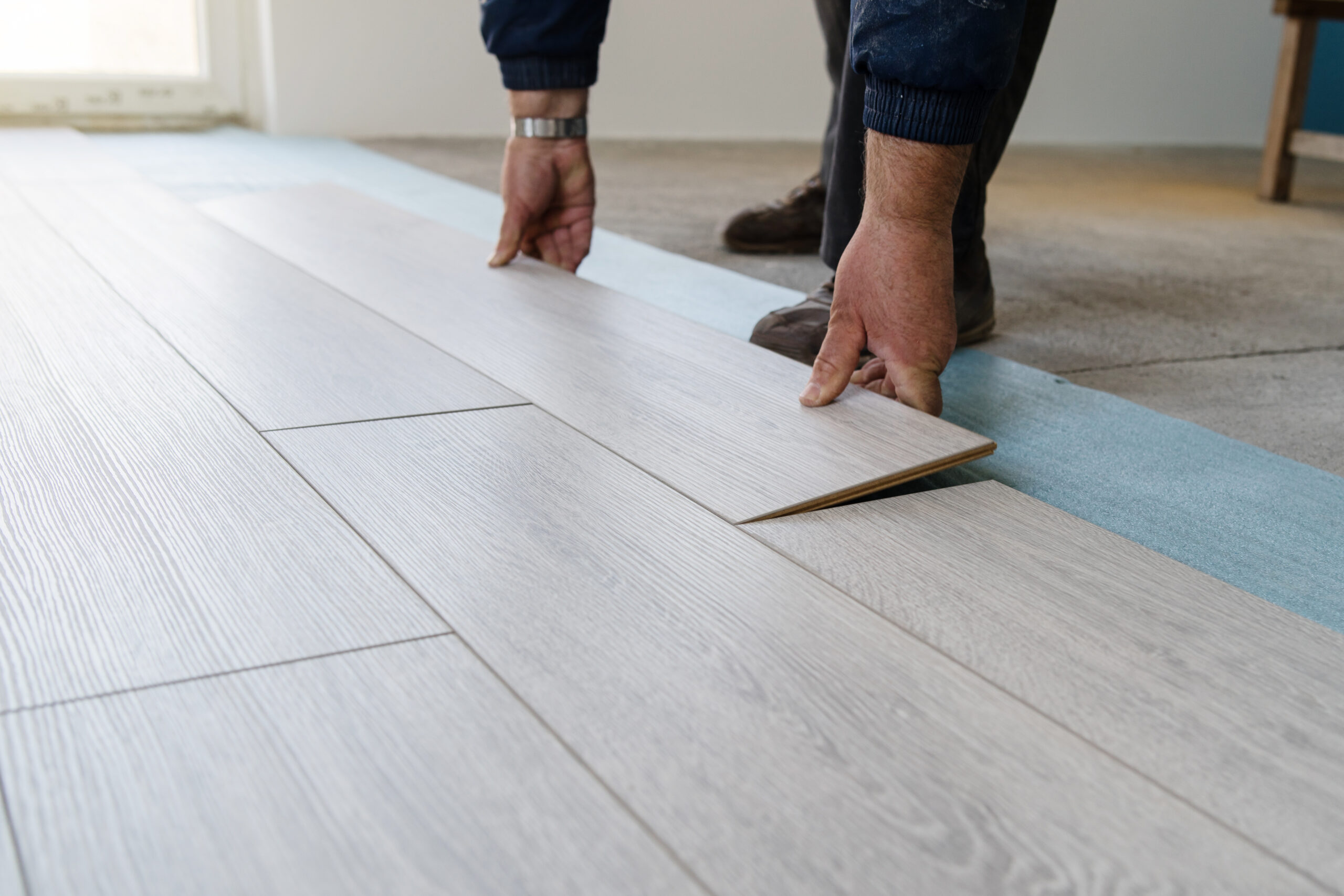Home renovate with vinyl laminate flooring. Professional construction worker installing new vinyl laminate floor tile